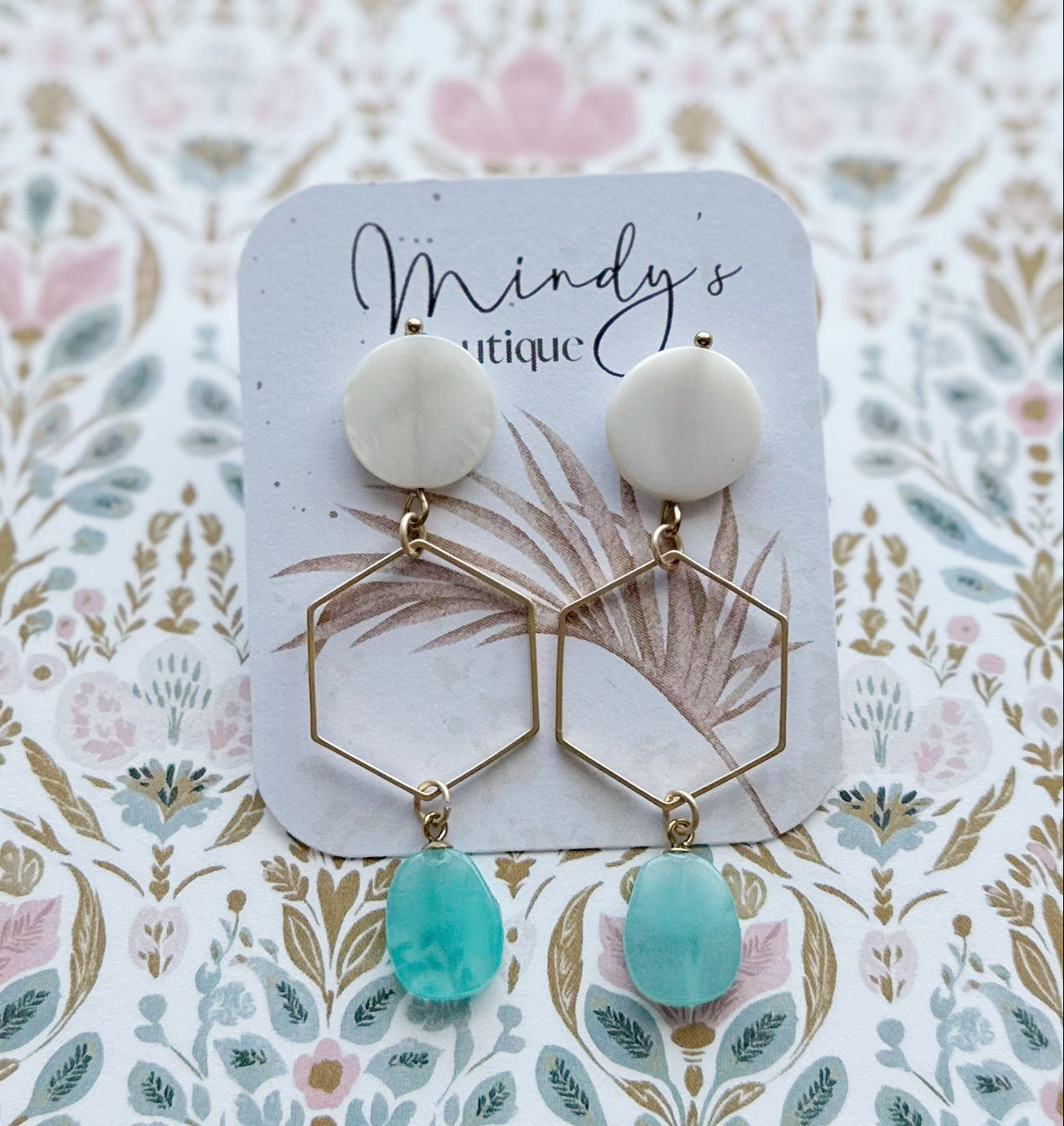 Earrings on a 'Mindy's Attic' branded card with a floral patterned background