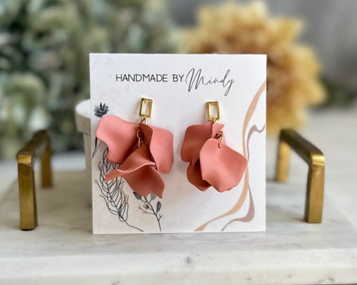 These Strawberry Wine Earrings are ideal for spring, featuring a delicate pink color and real gold plated posts in an open rectangle design. Their one-of-a-kind appearance is sure to elevate any outfit.
Hypoallergenic, lightweight, nickel, lead, and cadmium free.
Care Instructions:
To extend the life of your jewelry, it is highly recommended that your jewelry be removed and stored safely prior to sleeping, bathing, swimming, and exercising. Store in a clean, dry place. Keep clear of oils, creams, perfume