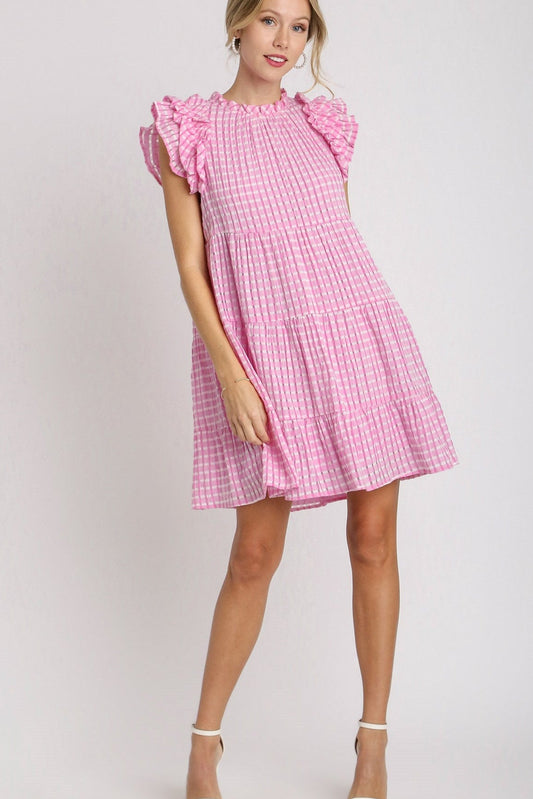 Woman wearing a pink checkered dress on a white background