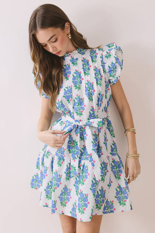 Woman wearing a floral dress against a plain background