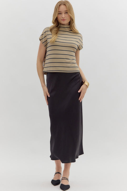 Woman wearing a striped top and black skirt on a white background