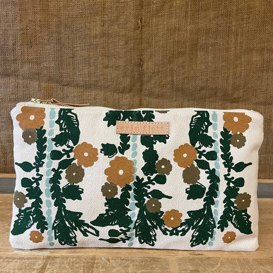 Floral patterned pouch on a wooden surface with a brown fabric background