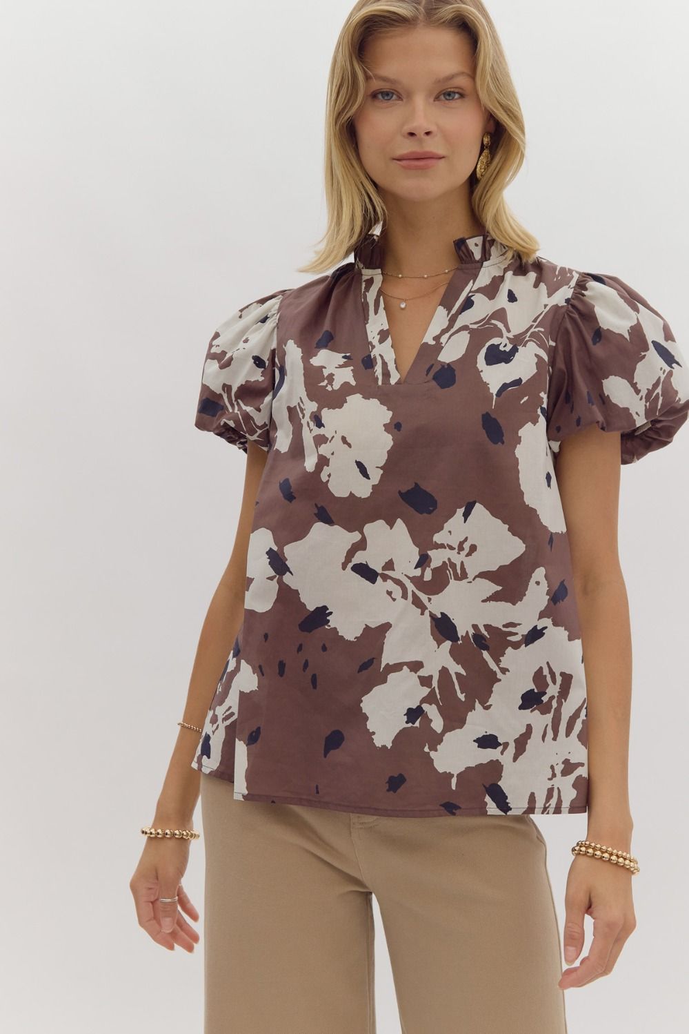 This professionally designed Kennedy Top features a charming v-neckline with playful puff sleeves and delicate ruffles. The lightweight, woven fabric is non-sheer and unlined for maximum comfort and style. Perfect for any occasion.