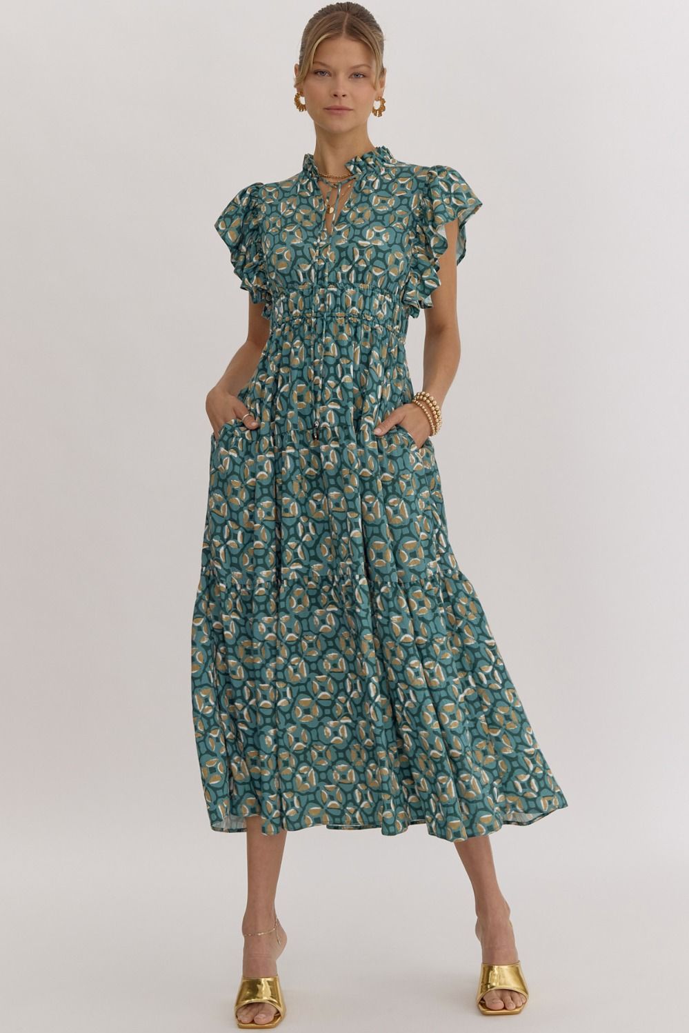 This midi dress features a printed v-neck and ruffle sleeves, with smocking at the waist and a self-tie at the neck. It also includes a pocket at the sides, as well as ruffle detailing. The dress is lined and made of a lightweight woven material that is not sheer.

Fabric Content:&nbsp; 85%RAYON 15%NYLON
Model&nbsp;5'10" and wearing size Small.
Color: Green&nbsp;