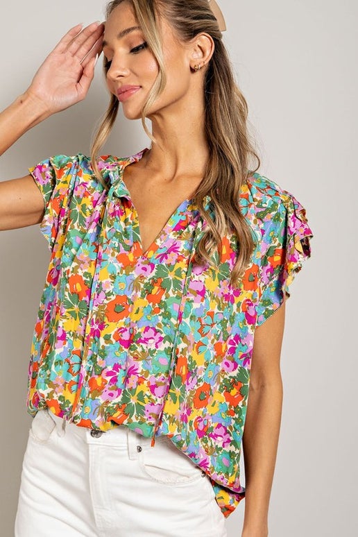 This top features a tie neck closure, ruffled sleeves, and a pinched back, all adorned with a beautiful floral print.

Model is 5'8" and is wearing a small.

Brand: eesome