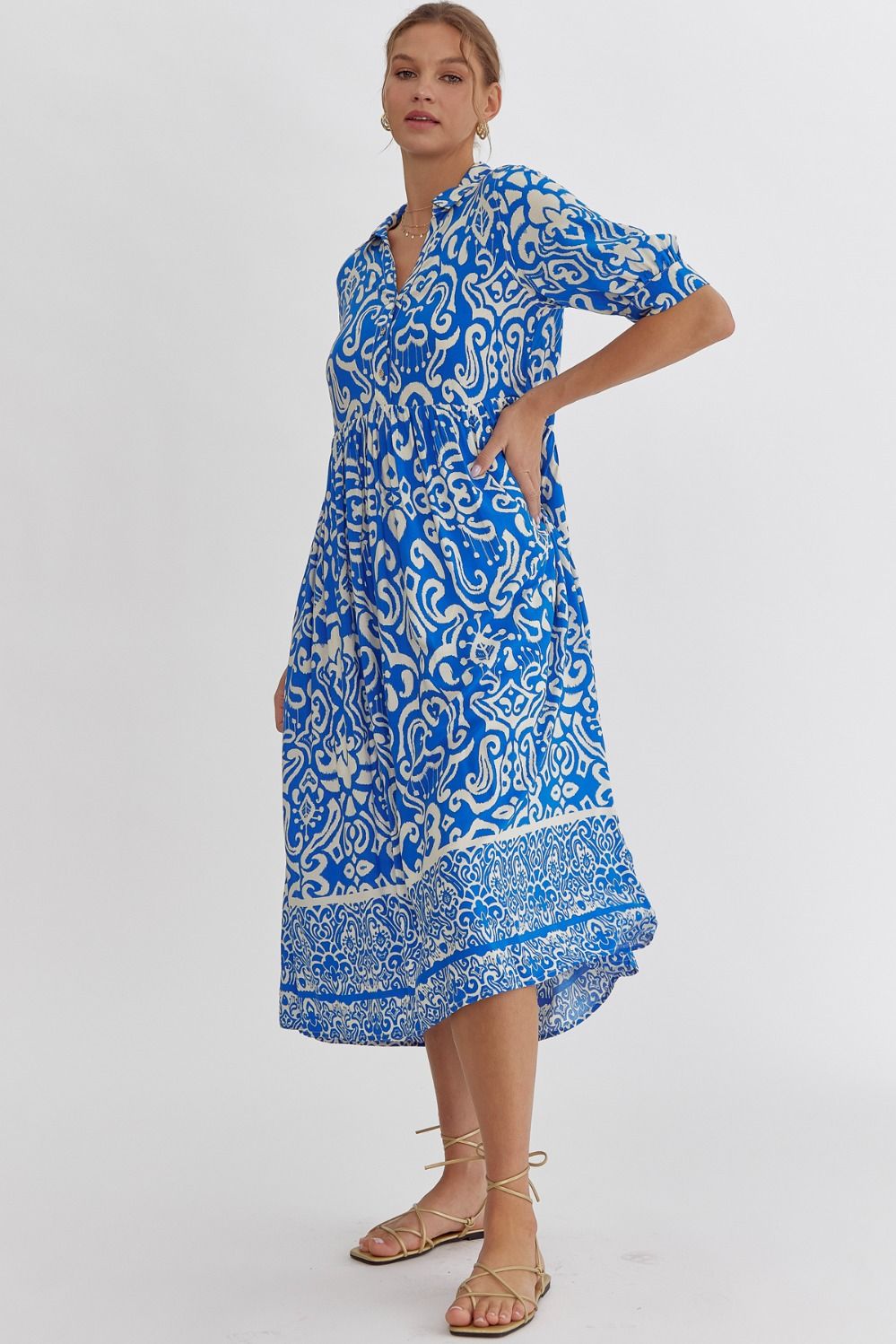 Woman wearing a blue and white patterned dress on a white background
